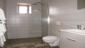 Un baño con ducha, inodoro y lavabo.