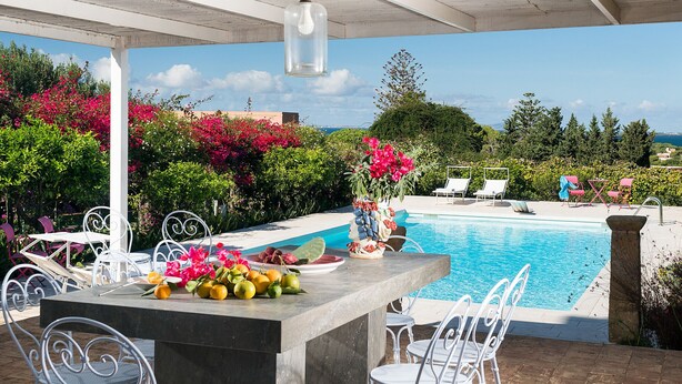 An outdoor pool area with a bar, white metal chairs, and a view of the sea. - Exclusive villa with pool, external kithchen, in Marsala, Sicily (Marsala)