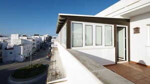 A residential building with a balcony overlooking a street. - 192 - Ático El Cielo (Conil de la Frontera)