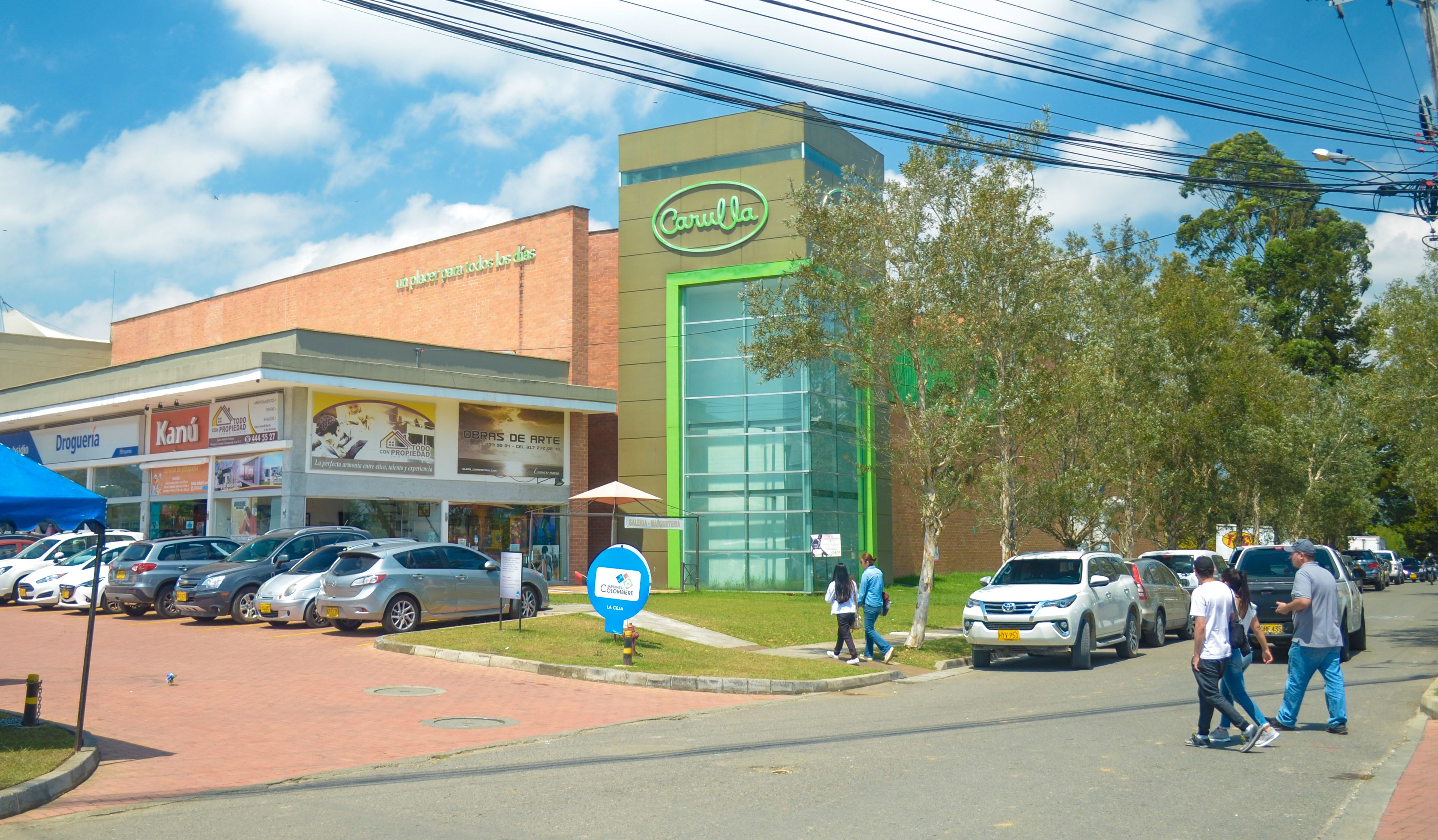 Un edificio comercial con fachada verde y un letrero que dice 'Carulla'.