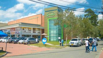 Un edificio comercial con fachada verde y un letrero que dice 'Carulla'.