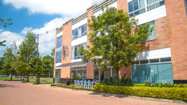 A modern building with a brick facade, large windows, and outdoor seating area. - Llanogrande Airport by Bernalo Hotels (Rionegro)