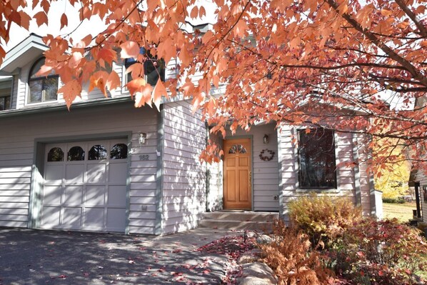 A two-story house with a garage, a front door, and a mailbox.
