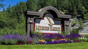 A sign for Mountain Harbor with a wooden background and a bird design.