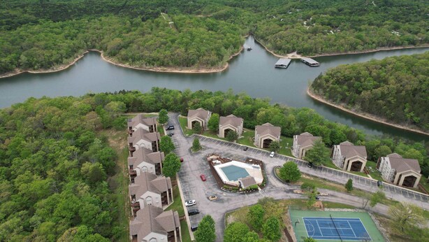 Zona residencial con un lago, cancha de tenis y muelle para embarcaciones.