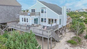 A two-story house with a deck, a hot tub, and a covered outdoor area. - Oceanfront Avon Home w/ Hot Tub, Foosball, Community Pool and Tennis/Pickleball (Avon)