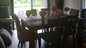 A dining area with a table, chairs, and a hanging light fixture. - Close to Aquatic Center, Horicon Marsh, Wedding Venue, Easy Drive to EAA (Waupun)