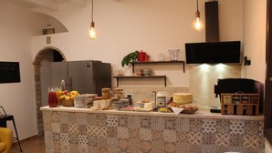 Una cocina con salpicadero de azulejos, un refrigerador, una cafetera y varios alimentos en la encimera.