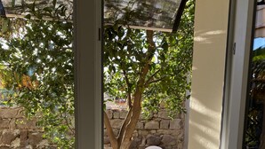 Un espace extérieur aménagé avec une table et des chaises, un arbre et un mur en pierre.