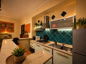 A modern kitchen with a central island, a built-in stove, and a stainless steel sink. - Andrea Apartment.  (Portoscuso)