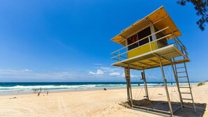 Ein Rettungsturm am Strand bei blauem Himmel.