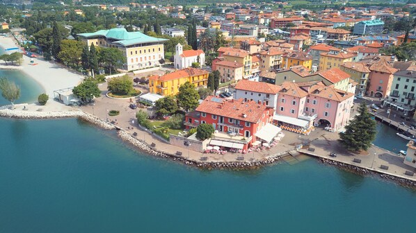 An aerial view of a coastal town with buildings, a marina, and a beach.