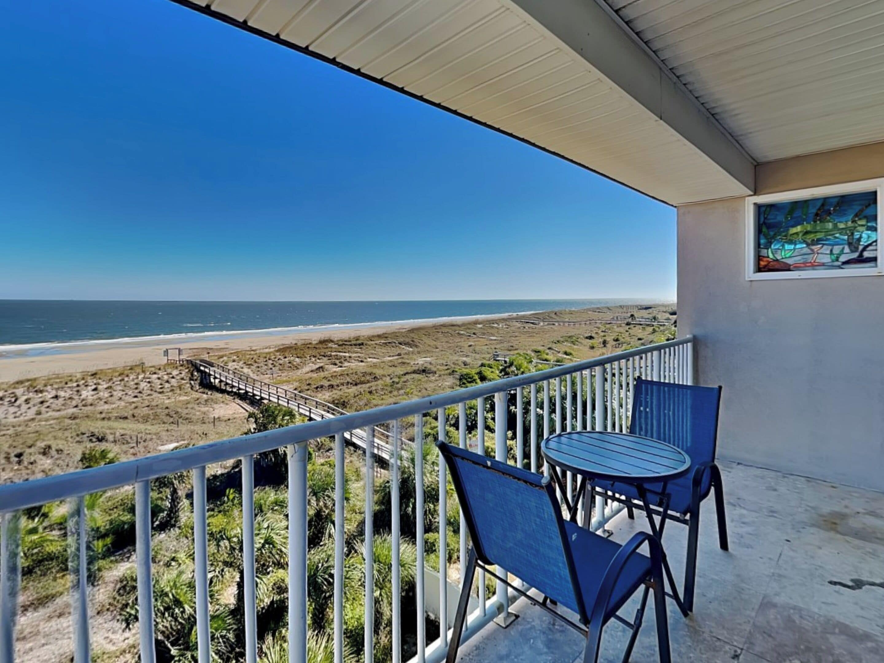 Ein Balkon mit Blick auf Strand und Meer.