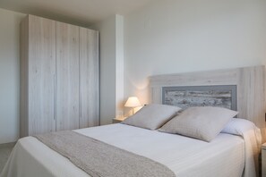 Une chambre à coucher avec un lit, une table de chevet, une lampe et une armoire.