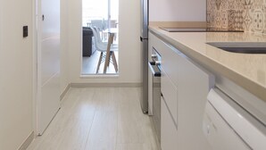 Een moderne keuken met witte kasten, een roestvrijstalen afzuigkap en een decoratieve spatwand.