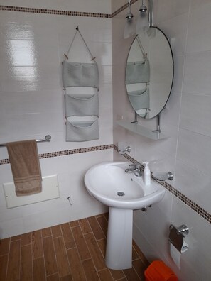 A bathroom with a white sink, a mirror, and a towel rack.