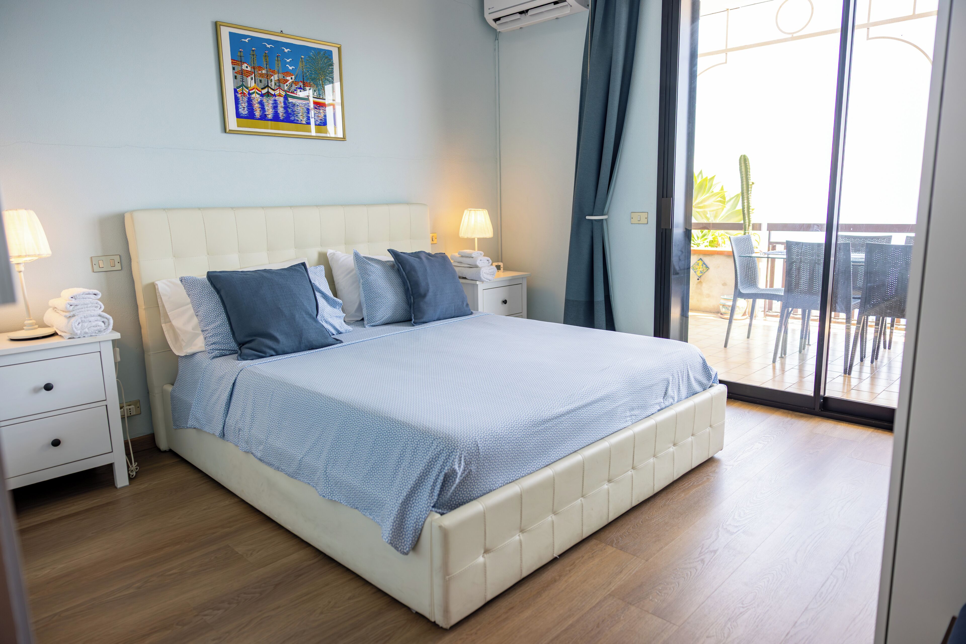 Une chambre d’hôtel avec un lit, des tables de chevet, une commode, une fenêtre avec des rideaux et une vue sur l’extérieur.