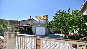 A two-story house with a covered patio, a garage, and a garden with potted plants and flowers. - Apartment in Vir with Terrace, Air condition, WIFI (4592-1) (Vir)