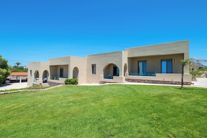 A modern building with multiple arched windows and a well-maintained lawn.