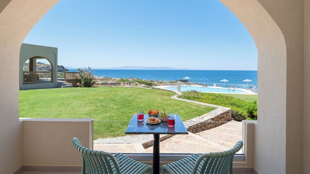 A patio with a table, chairs, and a view of the ocean. - Seafront luxury apartment with amazing sunset view 3 (Stavros,Chania)