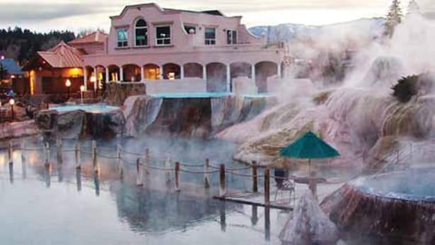A hotel with a spa area featuring hot springs and a building with a pink facade.