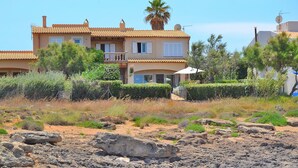 Une villa de style méditerranéen, dotée d’un toit en tuiles, d’un balcon et d’un jardin bien entretenu.