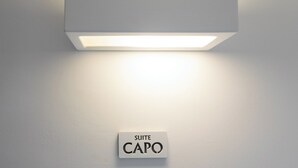 A wall-mounted light fixture with a sign below it reading "SUITE CAPO". - Suite behind the cathedral (Palermo)