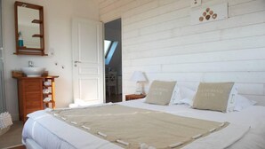 Ein Hotelzimmer mit einem großen Bett, einem Holzkonsolenmöbelstück mit Waschbecken, einem Spiegel und einem Kissen mit der Aufschrift 'RACING CLUB'.