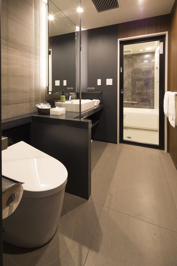 Un baño moderno con inodoro, lavabo y cabina de ducha.