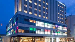 A modern hotel with multiple floors, large windows, and a prominent sign indicating a 40 km/h speed limit.