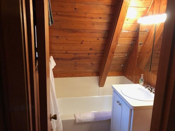 A wooden-paneled bathroom with a bathtub, a sink, and a mirror. - Little A-frame, Big porch on Lake Hamilton, Boat Dock, Deck, Fire pit, Kayaks (Hot Springs)