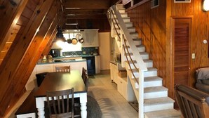 Un intérieur en bois comprenant un coin repas, une cuisine et un escalier.