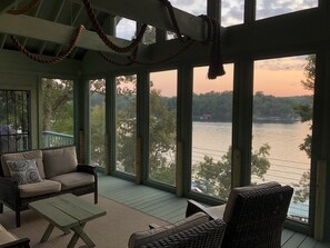 A covered porch with wicker furniture, large windows, and a view of a lake. - Little A-frame, Big porch on Lake Hamilton, Boat Dock, Deck, Fire pit, Kayaks (Hot Springs)