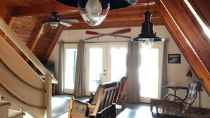 Un intérieur en bois comprenant un coin repas, un escalier et un ventilateur de plafond.