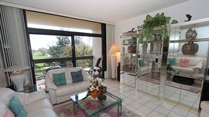 A living room with a sofa, coffee table, and a glass cabinet with decorative items.