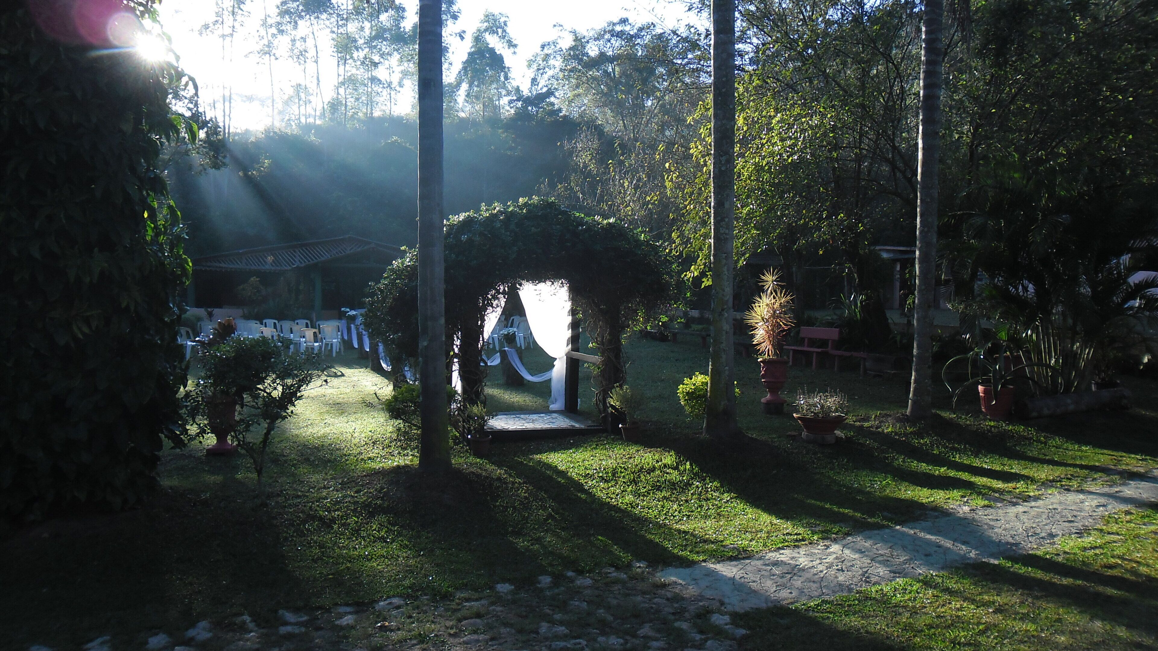 An outdoor garden area with a pathway leading to a covered seating area.