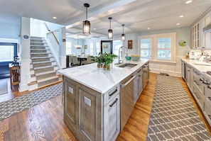 A spacious kitchen with a central island, wooden flooring, and pendant lighting. - Private Pool, Gourmet Kitchen, 2 1/2 Blocks to Beach, Close to Town (Rehoboth Beach)