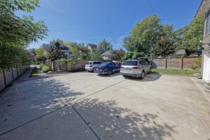 A residential driveway with two cars parked, a wooden fence, and houses in the background. - Private Pool, Gourmet Kitchen, 2 1/2 Blocks to Beach, Close to Town (Rehoboth Beach)