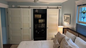 A bedroom with a bed, a ceiling fan, a bookshelf, and a window with a stained glass design. - 6 Bed/5 Bath with Pool - upgraded beds for 2026 (Rehoboth Beach)