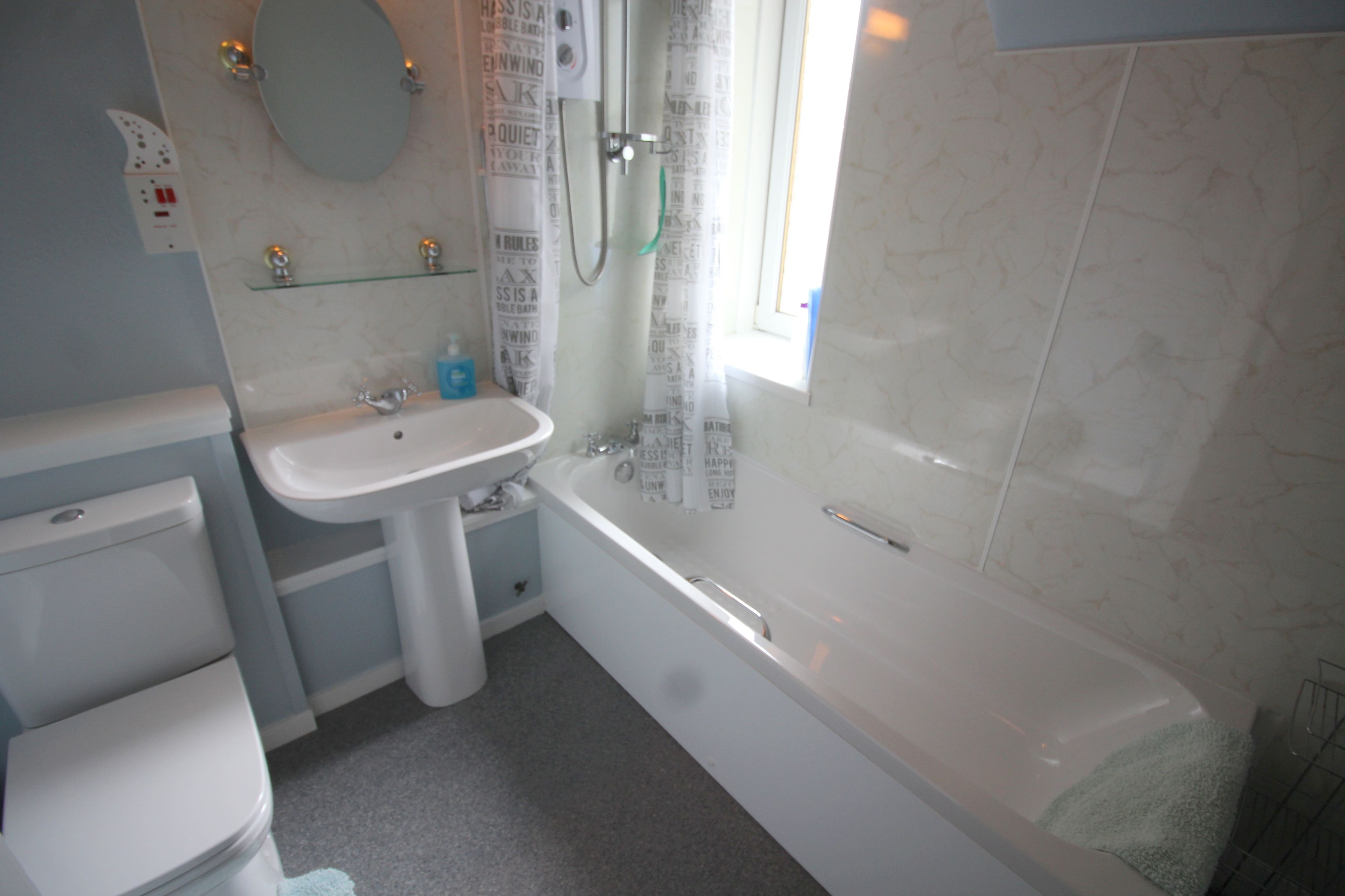 A bathroom with a toilet, sink, and bathtub.