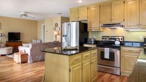 A modern kitchen with wooden cabinets, stainless steel appliances, and a built-in island. - Waterfront Home with Dock! (Fairhope)