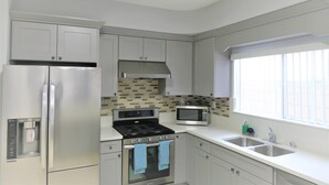 A modern kitchen with stainless steel appliances, a microwave, and a built-in oven. - Spacious Home* 7 minutes to Disneyland (Anaheim)
