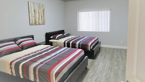 A bedroom with two beds, a window with blinds, and a painting on the wall. - Spacious Home* 7 minutes to Disneyland (Anaheim)