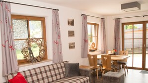 Ein gemütliches Wohnzimmer mit einem karierten Sofa, einem Holzesstisch und Stühlen.