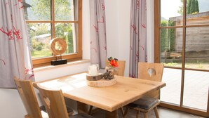 Ein Holztisch mit vier Stühlen, einer Kerze und einem dekorativen Mittelstück.