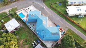 A large, modern house with a swimming pool, a garage, and a well-maintained lawn.