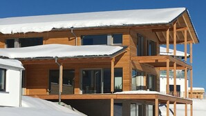 A multi-story wooden building with large windows and a balcony, surrounded by snow. - Dream vacation in the Allgäu in the eco house with a clear view of nature (Isny)