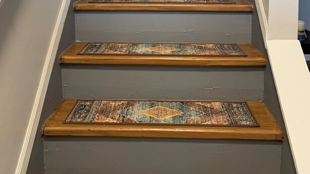 A staircase with wooden steps and a patterned carpet runner.