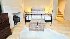 A bedroom with a bed, a dresser, a fireplace, and a staircase. - Notting Hill Newly Decorated 3-Bedrooms with large Private Garden (London)