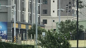 Een meerhoog gebouw met een modern architectonisch ontwerp, met een combinatie van balkons en ramen.